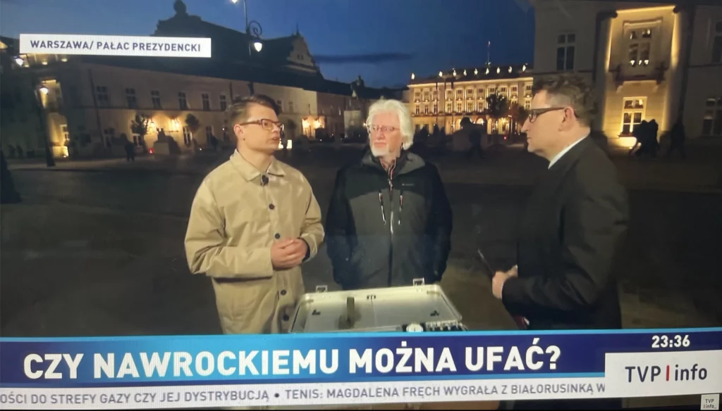 Jakub Kocjan rozmawia z dwoma mężczyznami przed Pałacem Prezydenckim nocą – kadr z programu TVP Info „Niebezpieczne Związki”, pasek „Czy Nawrockiemu można ufać?”