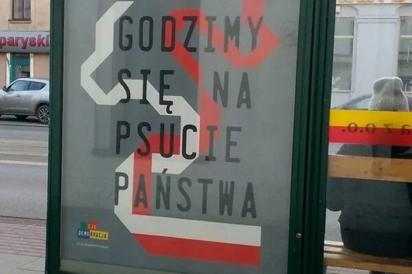 Plakat Akcji Demokracji „Nie godzimy się na psucie państwa” w gablocie na przystanku autobusowym
