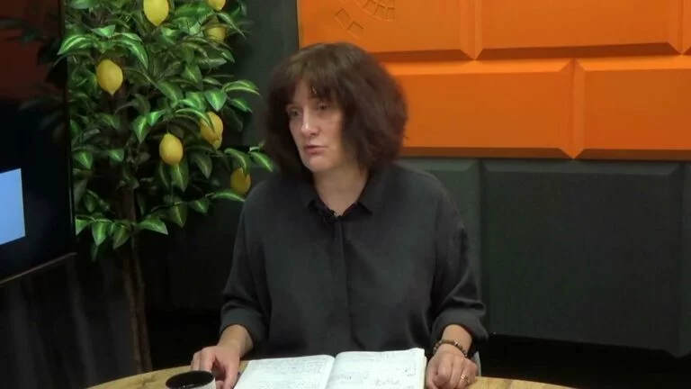 Kobieta w studiu Cafe Akcja rozmawia z gościem, obok drzewko cytrynowe