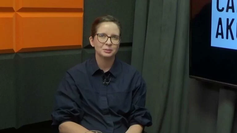 Anna Mazurczak w studiu Cafe Akcja na tle pomarańczowej ściany z logo programu