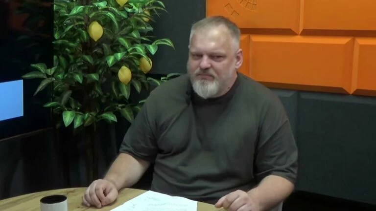 Mężczyzna z siwą brodą w studiu Cafe Akcja, obok drzewko cytrynowe