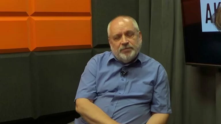 Robert Maślak w niebieskiej koszuli w studiu Cafe Akcja