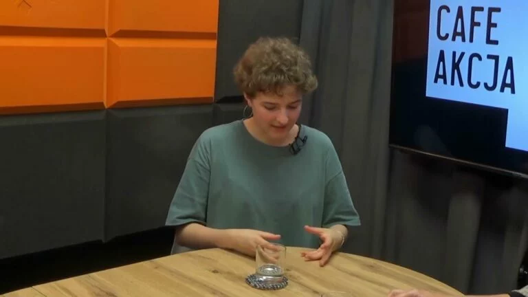 Dominika Lasota w studiu Cafe Akcja na tle logo programu