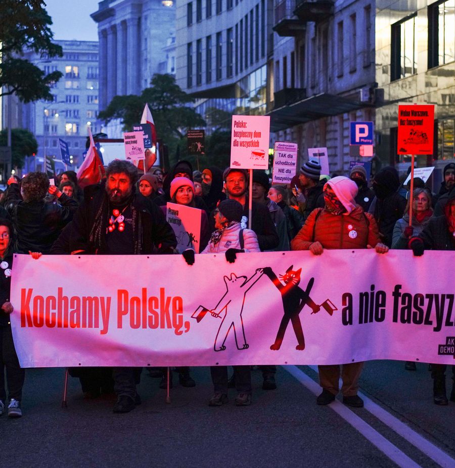 Marsz antyfaszystowski w Warszawie, ludzie niosą transparent Akcji Demokracji z hasłem „Kochamy Polskę, a nie faszyzm!”