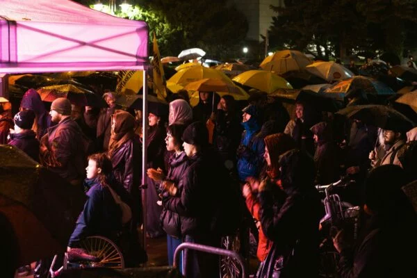 Protestujące osoby pod parasolami przy namiocie organizatorek