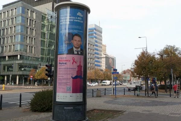 Słup ogłoszeniowy na rogu Marszałkowskiej i Żurawiej w Warszawie z plakatem Akcji Demokracji „Panie Mentzen, Twoi koledzy z AfD chcą znieść sankcje na Rosję”