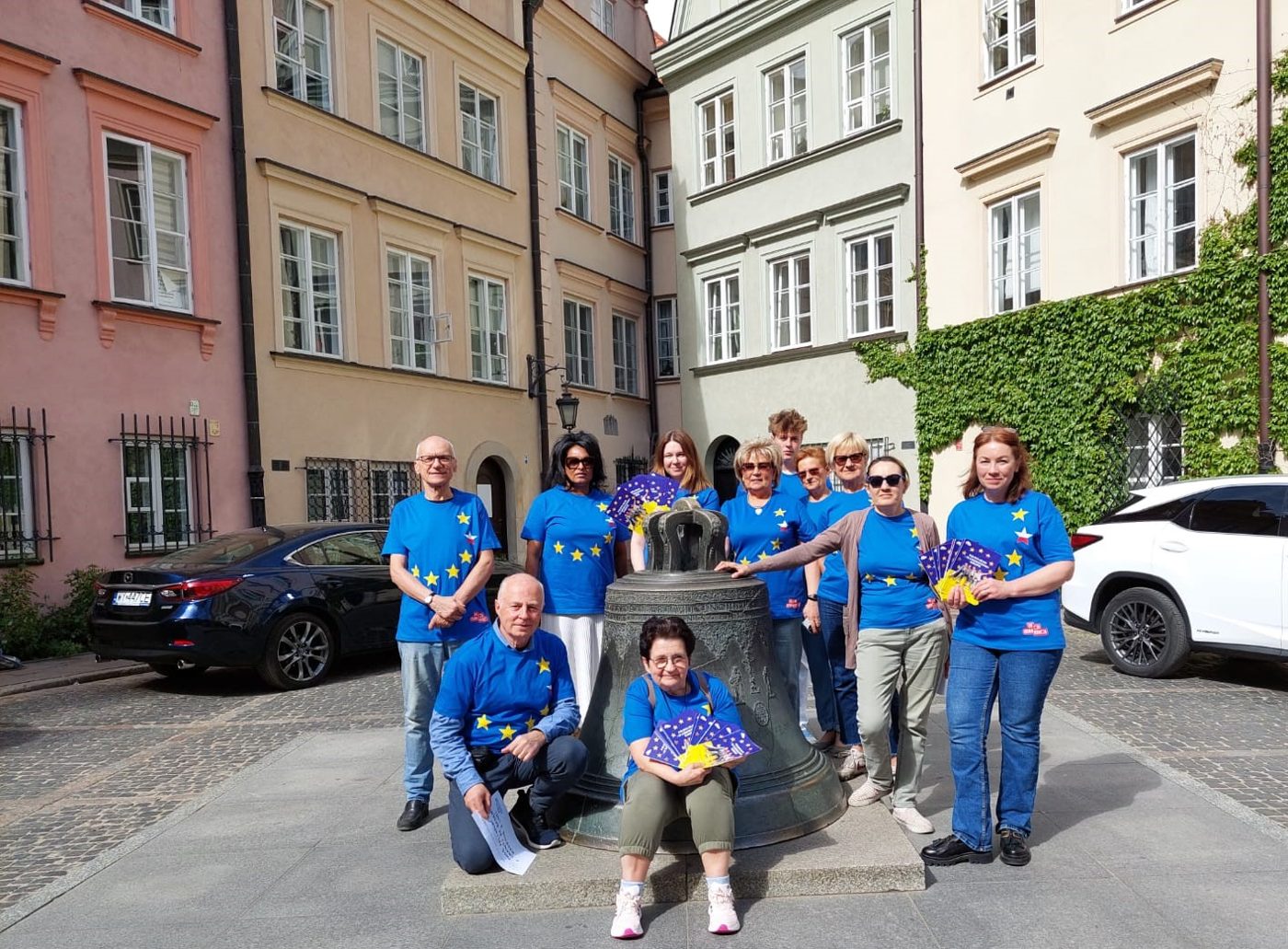 Wolontariuszki i wolontariusze w niebieskich koszulkach z ulotkami na warszawskim Starym Mieście